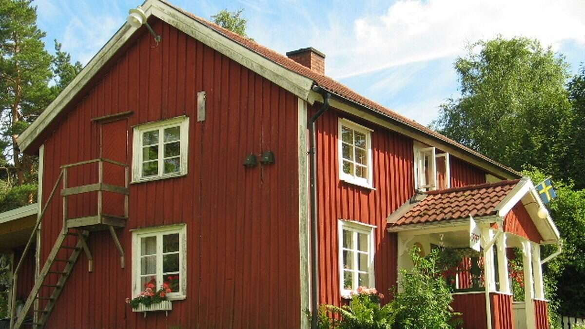 Traditionell röd svensk stuga med vita knutar
